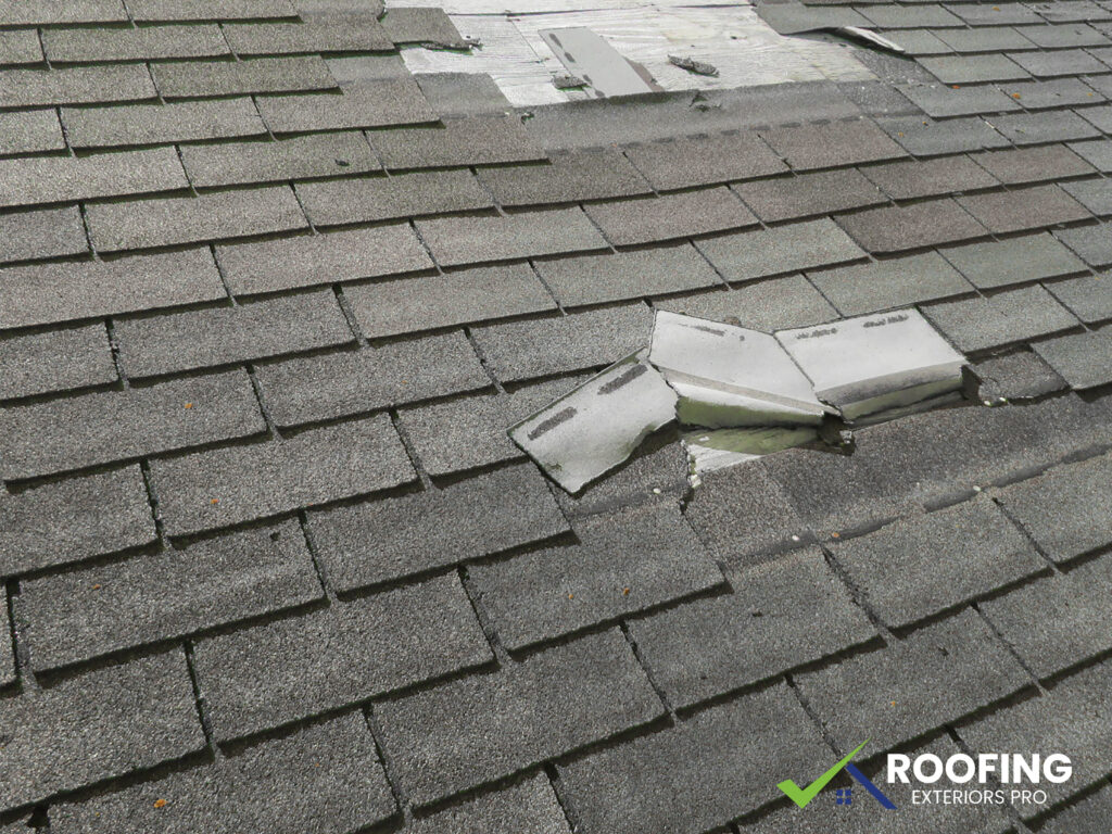 Storm damaged roof in Greensboro NC with missing shingles after high winds, repaired by Roofing Exteriors Pro